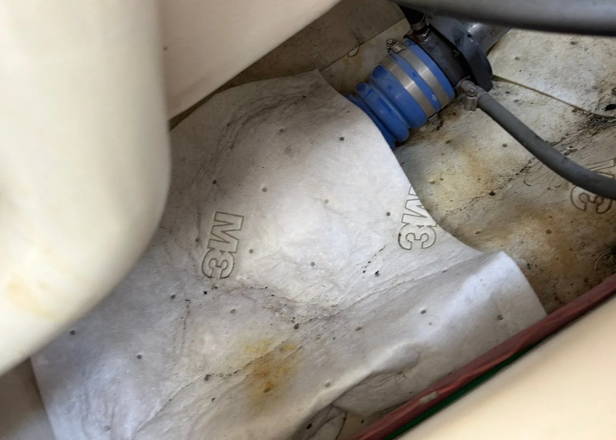 Rust staining and a weeping hose joint on fiberglass, the kind of detail that tells you a boat has been left alone